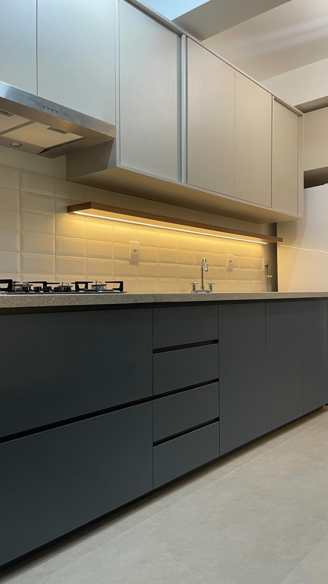 Cozinha planejada com armários pretos e nicho iluminado